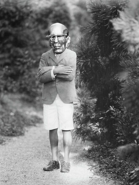 Person wearing a mask made by W.T. Benda, 1925 Sept. 20. Creator: Arnold Genthe