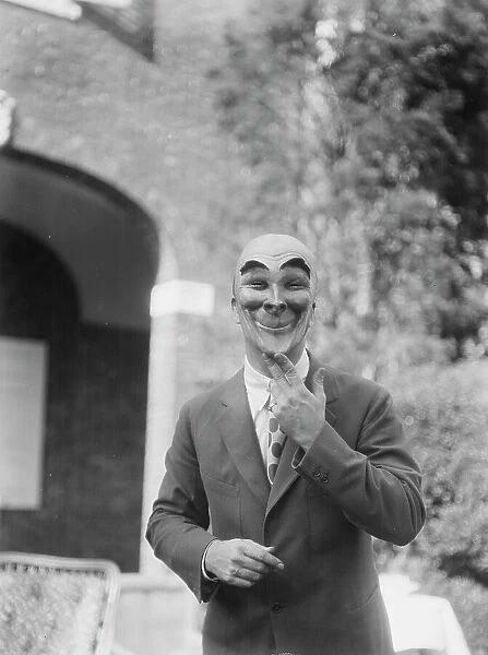 Person wearing a mask made by W.T. Benda, 1925 Sept. 20. Creator: Arnold Genthe