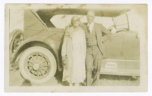Photograph of a man and woman in front of car, ca. 1921. Creator: Unknown