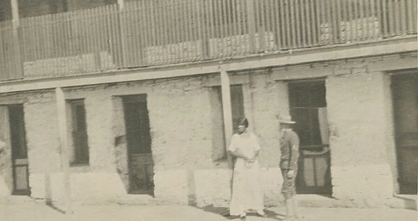 Photograph of a man and woman standing on a sidewalk, early 20th century