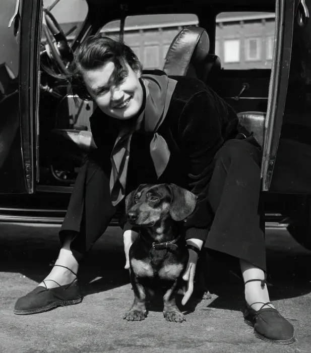 Framed Print : Photographer Kerstin Bernhard sits in the doorway of her car and holds a dachshund, 1955-1960. Creator: Unknown Framed Print : Photographer Kerstin Bernhard sits in the doorway of her car and holds a dachshund, 1955-1960. Creator: Unknown