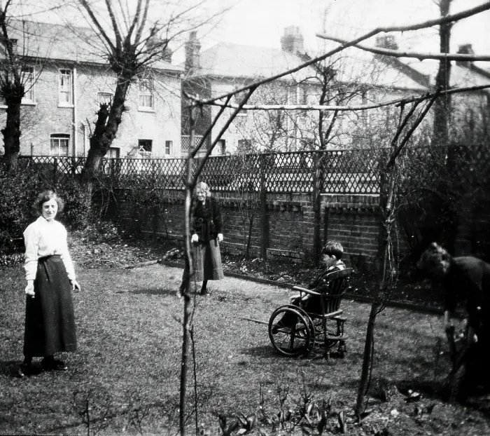 Framed Print : A physically disabled boy sitting in a wheelchair in the back garden of a semi... c1910 / 1925. Creator: Unknown Framed Print : A physically disabled boy sitting in a wheelchair in the back garden of a semi... c1910 / 1925. Creator: Unknown