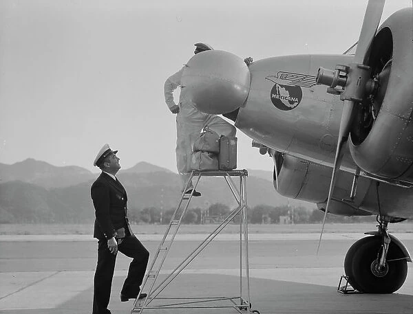 Plant quarantine inspectors examining plane at the Glendale Airport, California, 1937. Creator: Dorothea Lange