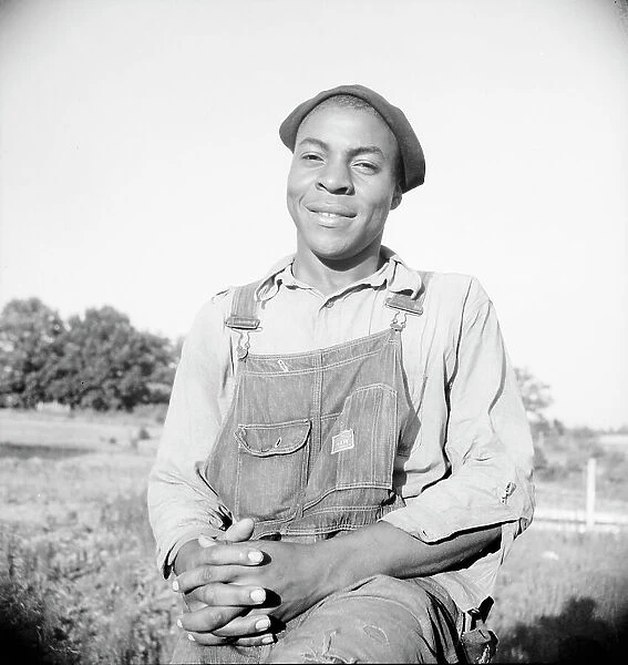 Plough boy sitting on fence after a day's work, Eutaw, Alabama, 1936. Creator: Dorothea Lange