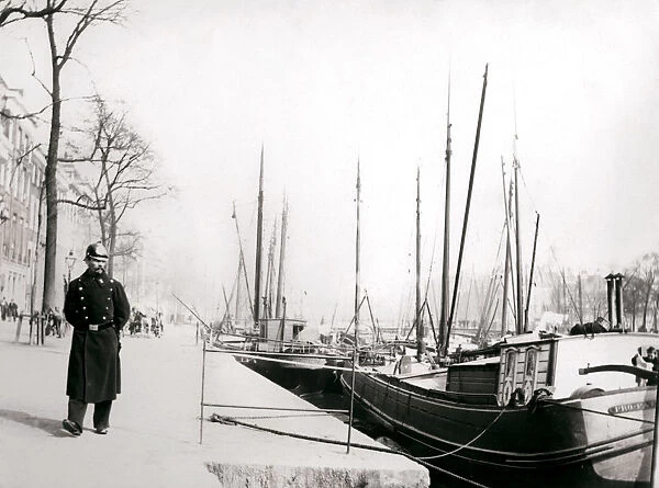 Policeman by a canal, Rotterdam, 1898. Artist: James Batkin