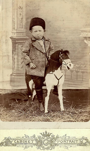 Portrait of a boy sitting on a toy horse, late 19th cent - early 20th cent. Creator: Unknown