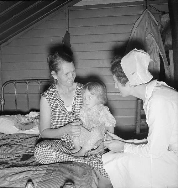 Resident nurse interviews mother and examines sick baby, FSA camp, Farmersville, CA, 1939. Creator: Dorothea Lange