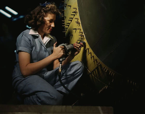 Riveter at work on Consolidated bomber, Consolidated Aircraft Corp. Fort Worth, Texas, 1942. Creator: Howard Hollem