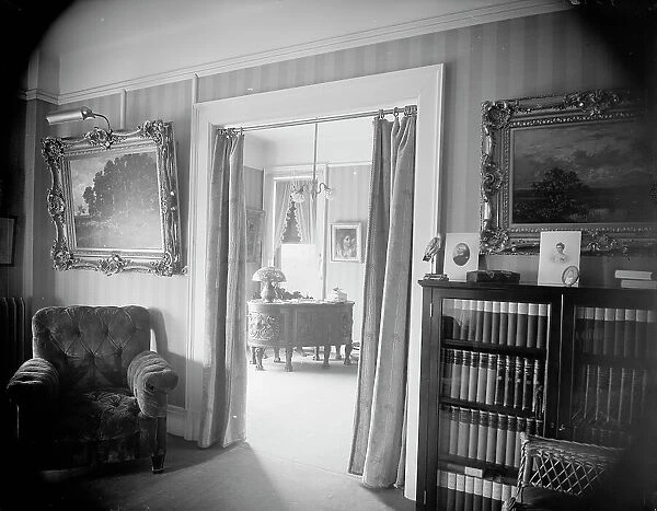Room with bookcase, study with desk, between 1900 and 1915. Creator: Unknown