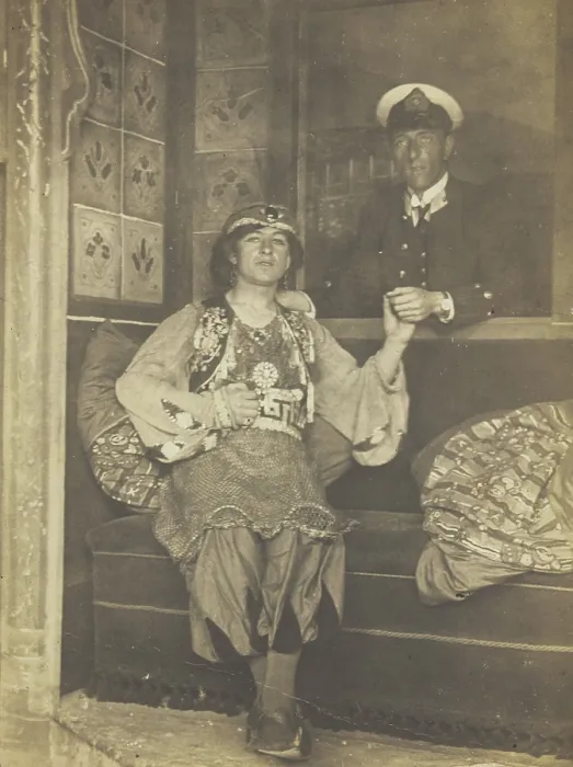 Framed Print : A sailor holds hands with a man in elaborate drag, [between 1910 and 1999?]. Creator: Unknown