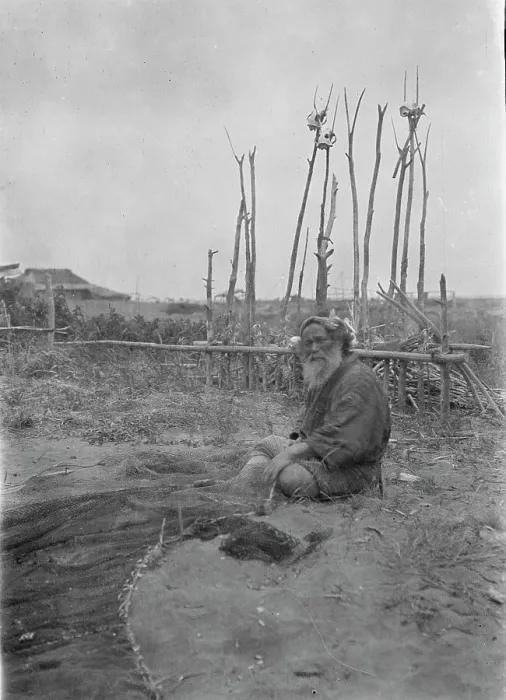 Framed Print : Seated Ainu man working on fishing nets, 1908. Creator: Arnold Genthe Framed Print : Seated Ainu man working on fishing nets, 1908. Creator: Arnold Genthe