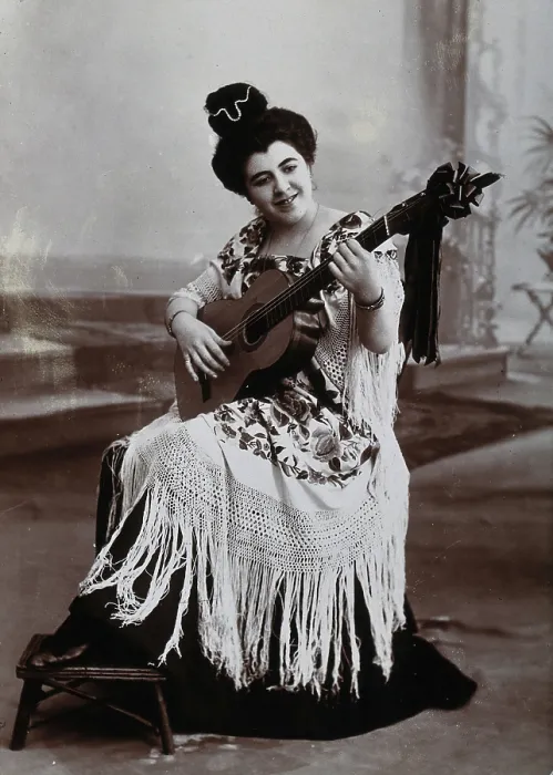 Framed Print : A seated woman, playing a guitar, wearing a fringed shawl, c1900. Creator: Unknown Framed Print : A seated woman, playing a guitar, wearing a fringed shawl, c1900. Creator: Unknown