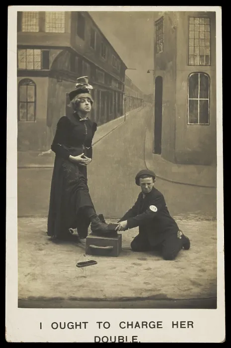 Framed Print : A shoeshine boy cleans the boots of a man in drag, c1905. Creator: Unknown Framed Print : A shoeshine boy cleans the boots of a man in drag, c1905. Creator: Unknown