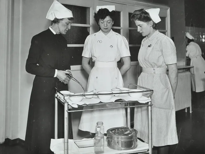 Framed Print : A Sister imparts knowledge and technical expertise to two trainee nurses, c1950s. Creator: Unknown Framed Print : A Sister imparts knowledge and technical expertise to two trainee nurses, c1950s. Creator: Unknown