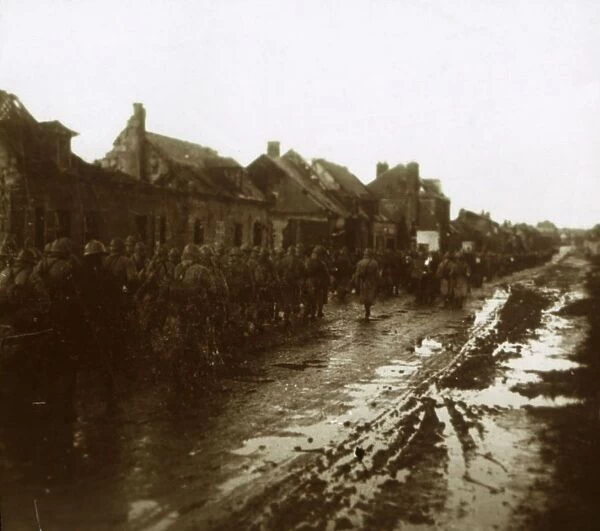 Soldiers marching past bombed-out houses, Champagne, northern France, c1914-c1918
