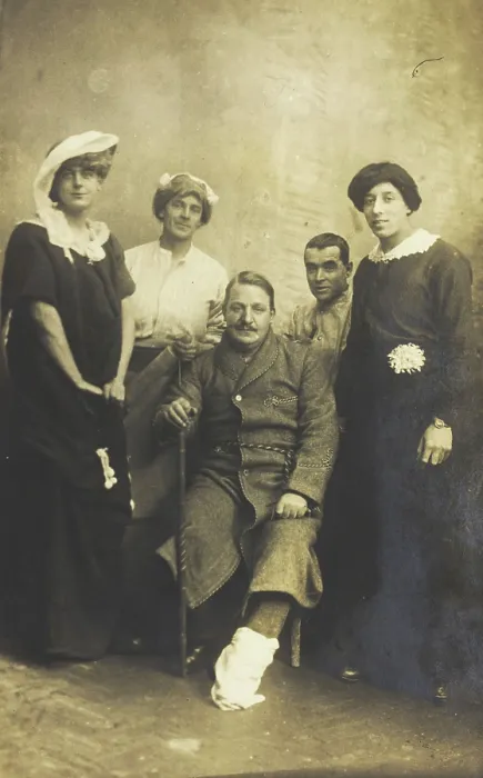 Framed Print : Four soldiers posing, three in drag, with an injured soldier seated in the centre, [1910-1919?]. Creator: Unknown