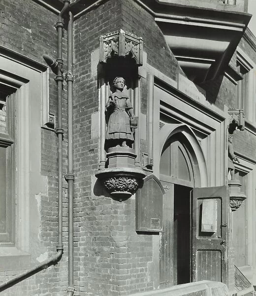 Statue of a girl scholar beside the door, Hamlet of Ratcliff Schools, Stepney, London, 1945