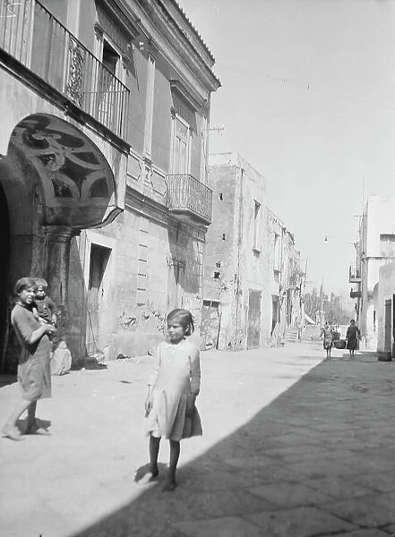Street scene in an unknown country, possibly in Central America or Spain, between 1911 and 1942. Creator: Arnold Genthe