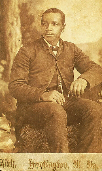 Studio portrait of unidentifed young man, seated on prop hay bale, c1870-c1879. Creator: George Wolleston Kirk