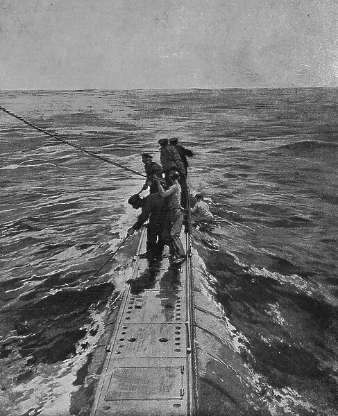 Sur le pont du sous-marin : les marins britanniques sauvant ceux qui, une... 1916. Creator: Unknown
