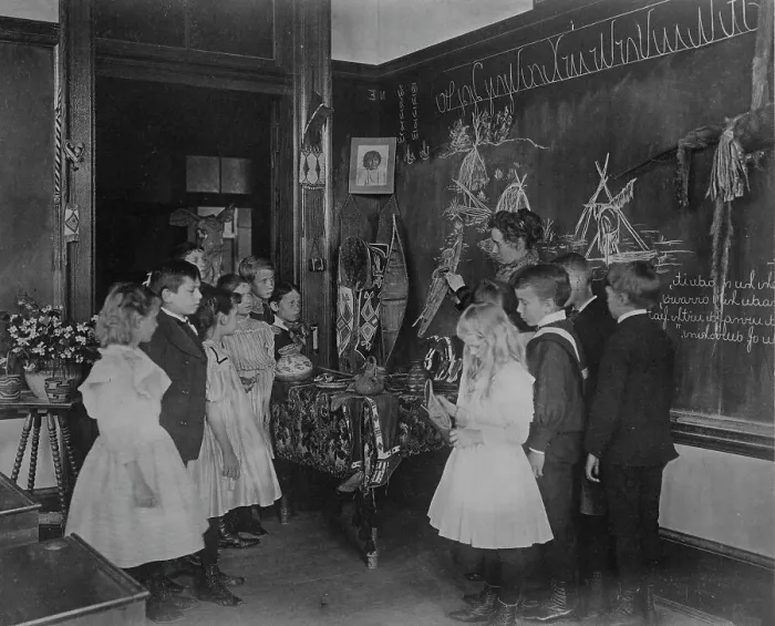 Framed Print : Teacher showing students Native American handicrafts at a school in Washington, D.C. (1899?). Creator: Frances Benjamin Johnston Framed Print : Teacher showing students Native American handicrafts at a school in Washington, D.C. (1899?). Creator: Frances Benjamin Johnston