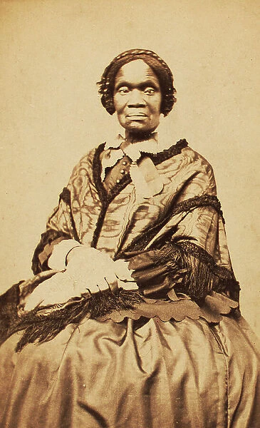 Three-quarter length portrait of unidentified woman dressed with long-fringed shawl, c1870-c1879. Creator: George W Hennigar