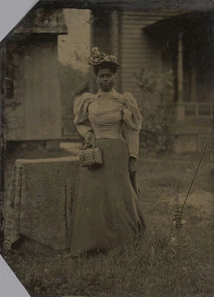 Tintype of a woman wearing a dress with hat and bag, 1890s. Creator: Unknown
