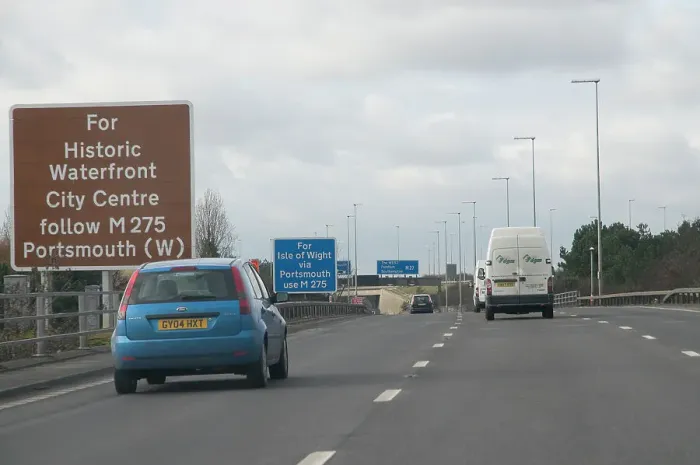 Framed Print : Traffic on M27 Motorway with brown tourist information sign Framed Print : Traffic on M27 Motorway with brown tourist information sign