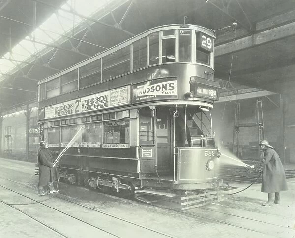 Transport workers washing a tram at the Holloway Car Shed, London, 1932