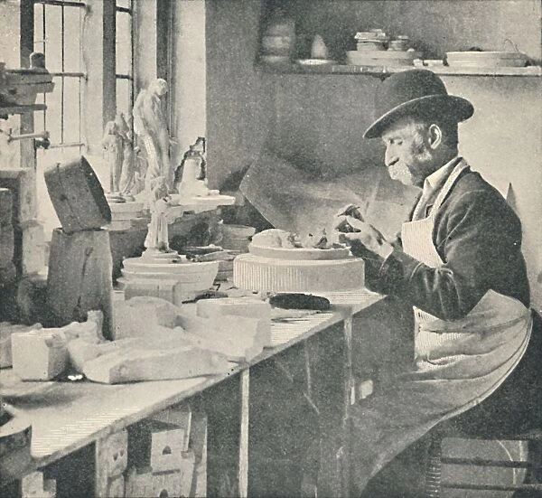Trimming up parts of raw clay, c1917