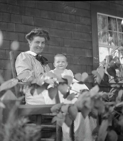 Unidentified woman and baby, seated on porch, between 1911 and 1942. Creator: Arnold Genthe