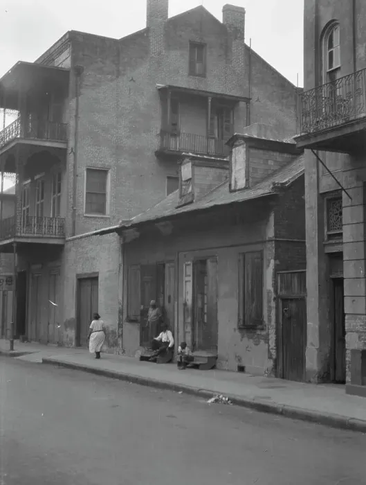 Framed Print : View from across street of a man and child sitting on steps and a woman walking down... c1920-1926. Creator: Arnold Genthe Framed Print : View from across street of a man and child sitting on steps and a woman walking down... c1920-1926. Creator: Arnold Genthe