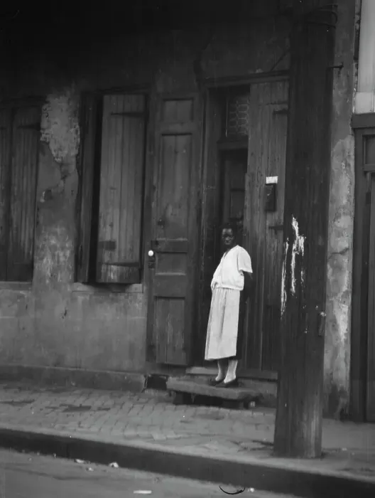 Framed Print : View from across street of a woman standing in a doorway in the French Quarter, New... c1920-c1926. Creator: Arnold Genthe Framed Print : View from across street of a woman standing in a doorway in the French Quarter, New... c1920-c1926. Creator: Arnold Genthe