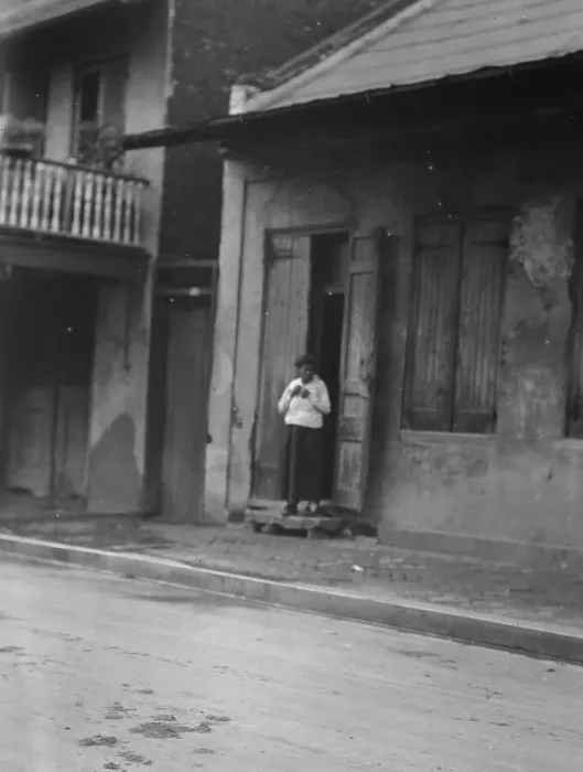 Framed Print : View from across street of a woman standing in a doorway in the French Quarter, New... c1920-c1926. Creator: Arnold Genthe Framed Print : View from across street of a woman standing in a doorway in the French Quarter, New... c1920-c1926. Creator: Arnold Genthe