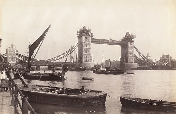 View of Tower Bridge under construction with river traffic in the foreground, London, c1893
