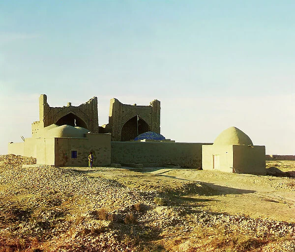 Walled adobe structure with domes and arches in desert area, with man posed... between 1905-1915. Creator: Sergey Mikhaylovich Prokudin-Gorsky