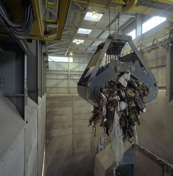Waste ready for incineration in giant crane grab jaws, St Helier, Jersey, 1980. Artist