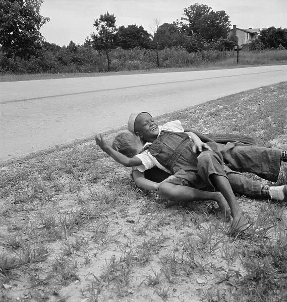 White and Negro boy wrestling by side of road, Person County, North Carolina, 1939. Creator: Dorothea Lange