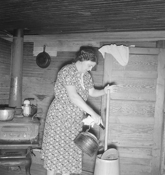 Wife of tobacco sharecropper cleaning butter churn, Person County, North Carolina, 1939. Creator: Dorothea Lange