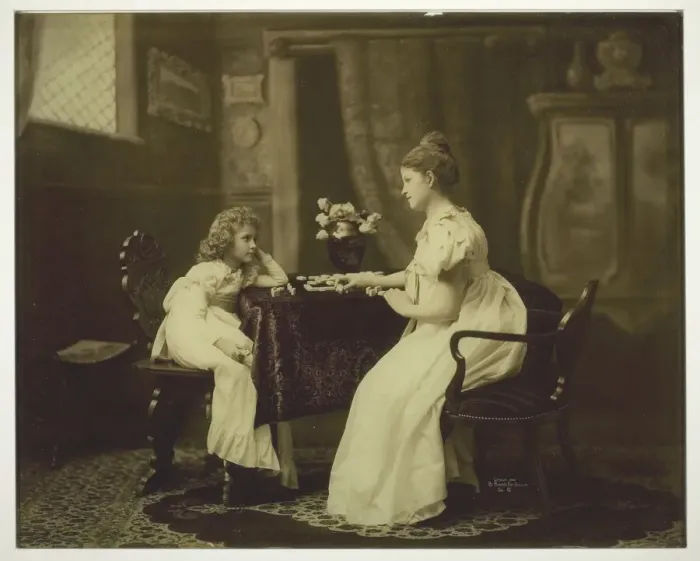 Framed Print : Woman and Child Playing Dominoes at Table, c. 1898. Creator: Unknown Framed Print : Woman and Child Playing Dominoes at Table, c. 1898. Creator: Unknown