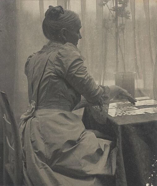 Woman Playing Solitaire, c.1910. Creator: Gertrude Kasebier