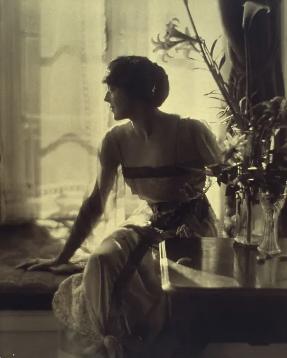 Framed Print : Woman sitting on window seat, looking left, full-length portrait, between 1900 and 1920. Creator: Unknown Framed Print : Woman sitting on window seat, looking left, full-length portrait, between 1900 and 1920. Creator: Unknown
