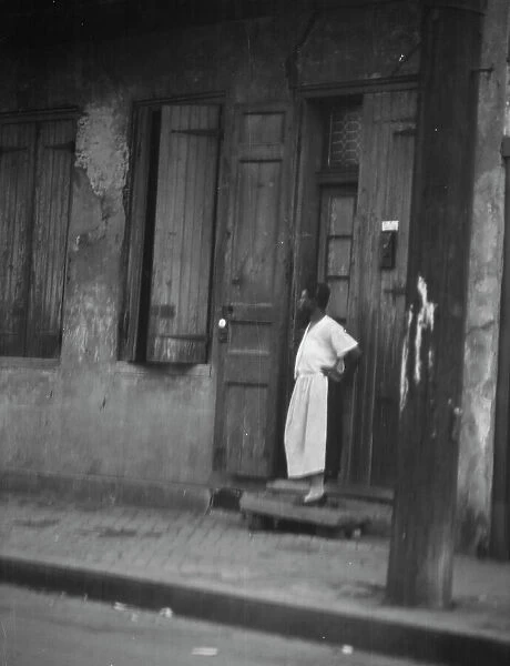 Woman standing in a doorway in the French Quarter, New Orleans, between 1920 and 1926. Creator: Arnold Genthe