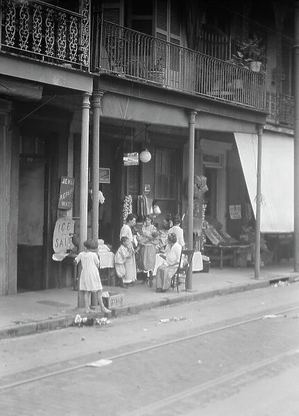 Women and children standing on a covered sidewalk, New Orleans, between 1920 and 1926. Creator: Arnold Genthe