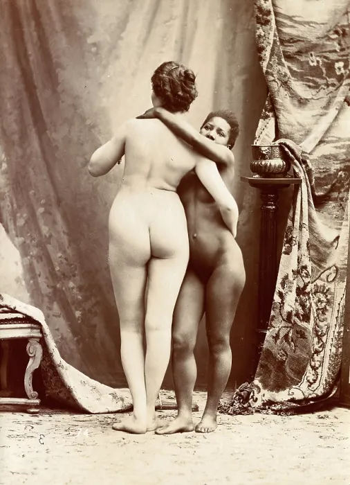 Framed Print : Two women posing naked in a photographic studio, standing embracing each other in front... c1900. Creator: Unknown Framed Print : Two women posing naked in a photographic studio, standing embracing each other in front... c1900. Creator: Unknown