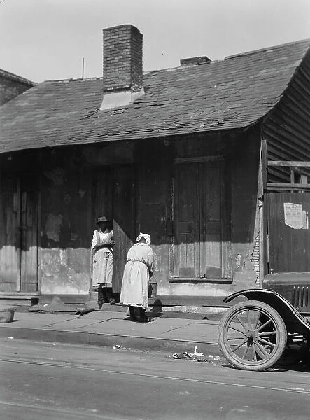 Two women standing in or by a doorway, New Orleans, between 1920 and 1926. Creator: Arnold Genthe