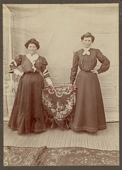 Framed Print : Two women standing at a table holding flowers, about 1875. Creator: Unknown Framed Print : Two women standing at a table holding flowers, about 1875. Creator: Unknown