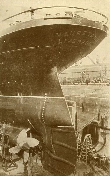 At Work on the Stern of the Mauretania, in Dry Dock, c1930. Creator: Unknown