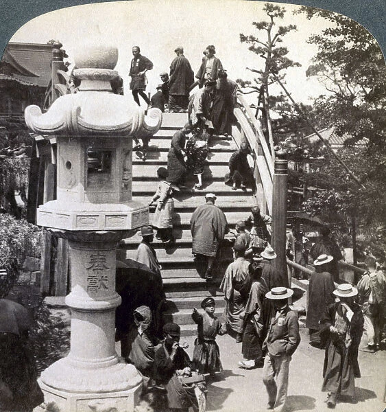 Worshippers crossing the semi-circular bridge to Kameido Temple beyond, looking north, Tokyo, Japan, Artist: Underwood & Underwood