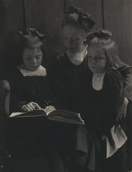 Three young girls reading a book, c1900. Creator: Gertrude Kasebier